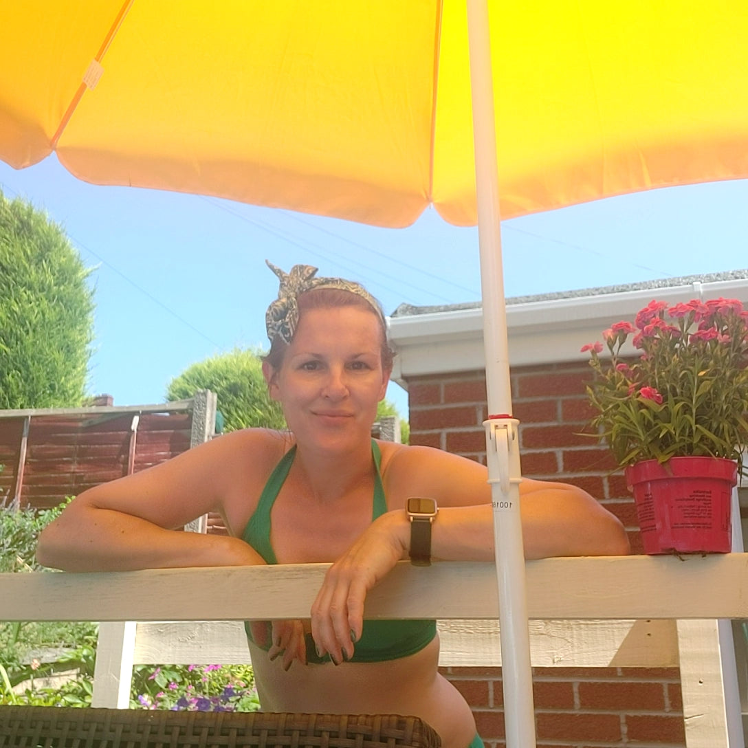 In green bikini under yellow umbrella 